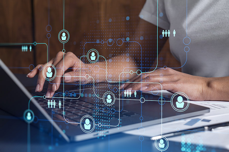 Hands of woman hr specialist is typing the keyboard in the internet to find the best candidates to create international network in recruitment process. Casual wear. Social media hologram icons.