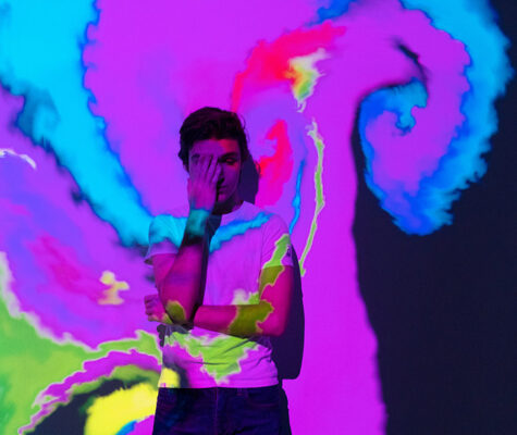 alented Innovative boy with an interactive virtual video installation. New art form, generative graphics. Silhouette of young man draws digital art in augmented virtual reality