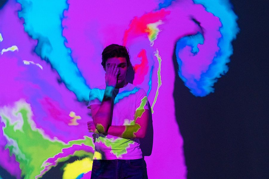 alented Innovative boy with an interactive virtual video installation. New art form, generative graphics. Silhouette of young man draws digital art in augmented virtual reality