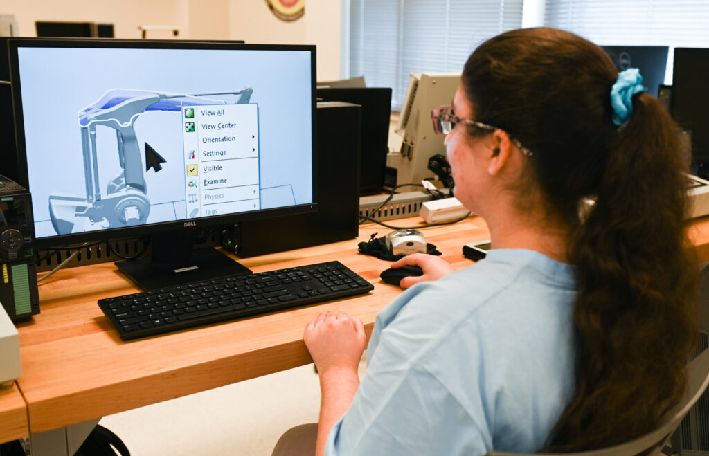 Fatimah Musa demonstrates Wednesday, Apr. 5, 2023 some of the equipment that she uses to compensate in class for vision loss.