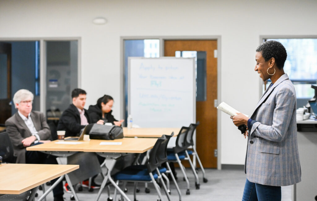 Woman addresses crowd during a business presentation.