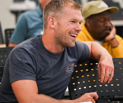 A military veteran engages in a discussion during a business course. Returning to school to earn an advanced degree can benefit many military veterans.