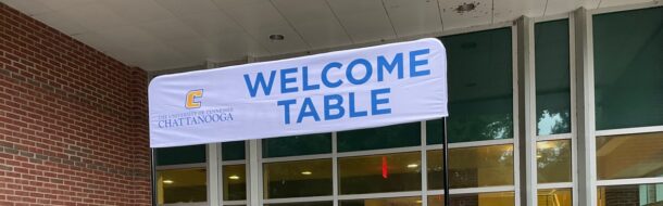 Welcome Table from Welcome Week includes staff members showing Power C's and swag