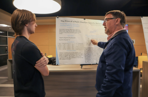 Justin Jackson, discusses his project with Center for Regional Economic Research Director Howard Wall at the Econometrics Research Symposium. 