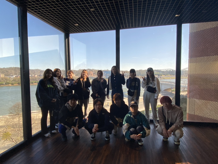 A group of students poses at the top of the Tennessee Aquarium.