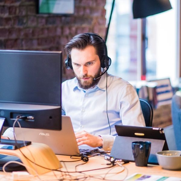 man providing customer service at his laptop