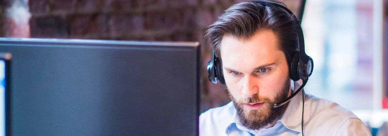 man providing customer service at his laptop