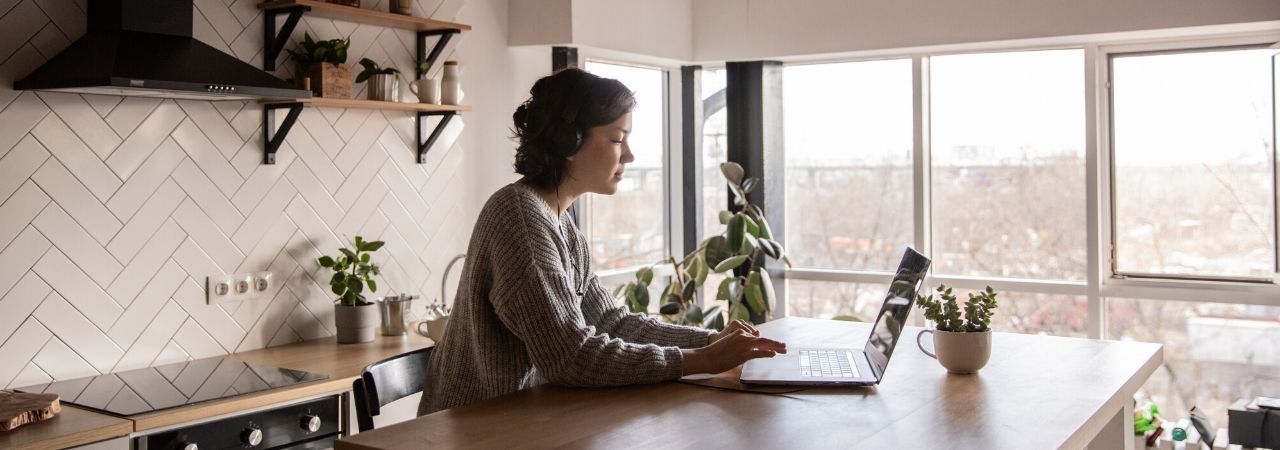 woman using her laptop in her kitchen