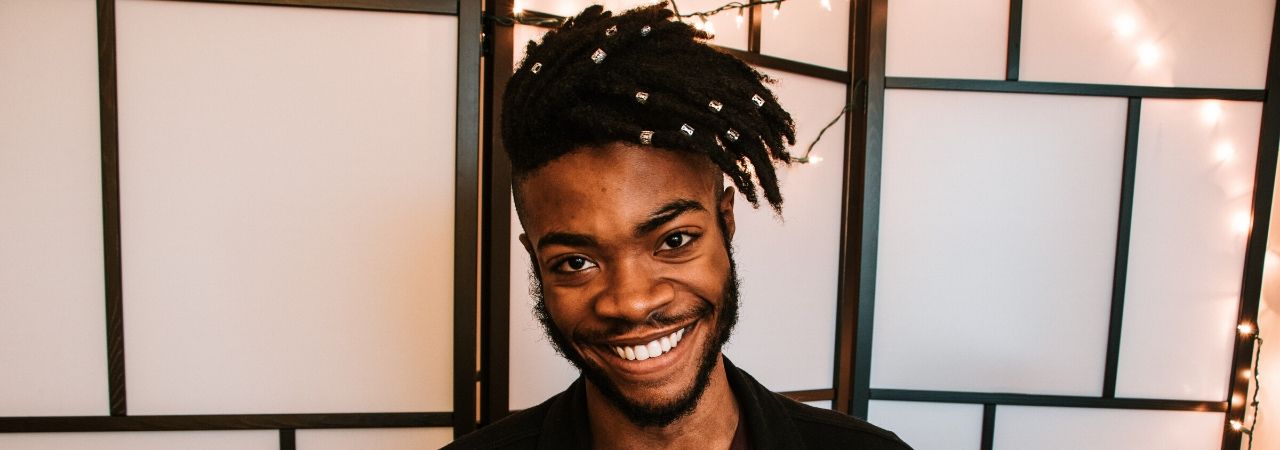 man smiling while holding his cell phone