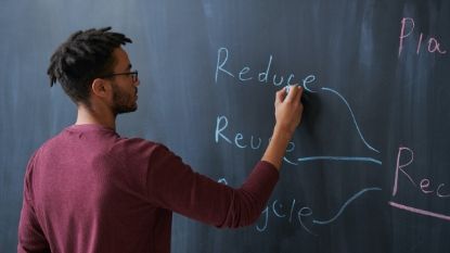 male teacher writing on a chalkboard