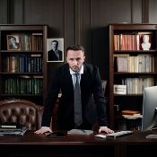 a man leaning over the top of his desk with an intense face