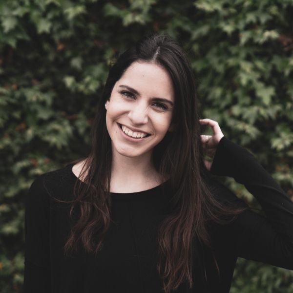 woman smiling in front of greenery
