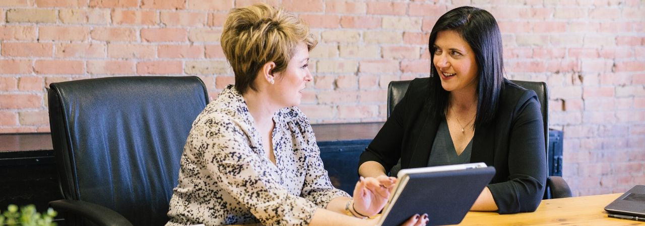 two women speaking in an office