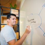 male creating a strategy on a white board
