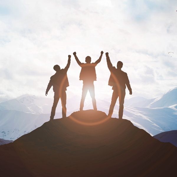 team of three men on top of a mountain with a red silhouette circle around the leader
