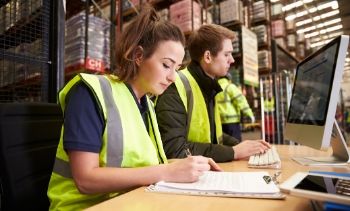 man and woman managing warehouse logistics in an on-site office