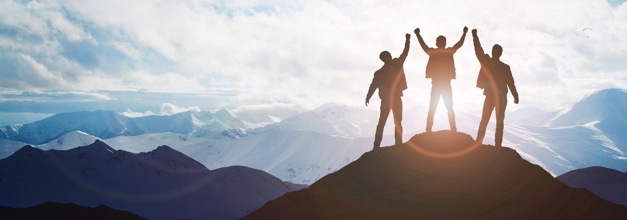 team of three men on top of a mountain with a red silhouette circle around the leader