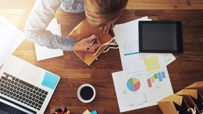 woman working on projects as she sits with her laptop open
