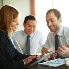 Portrait of smart businesswoman showing her partners something in touchpad at meeting