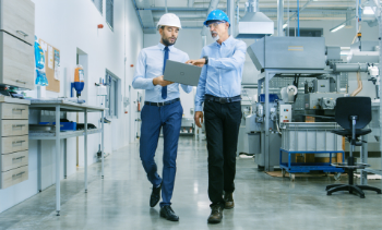 two men walking through factory