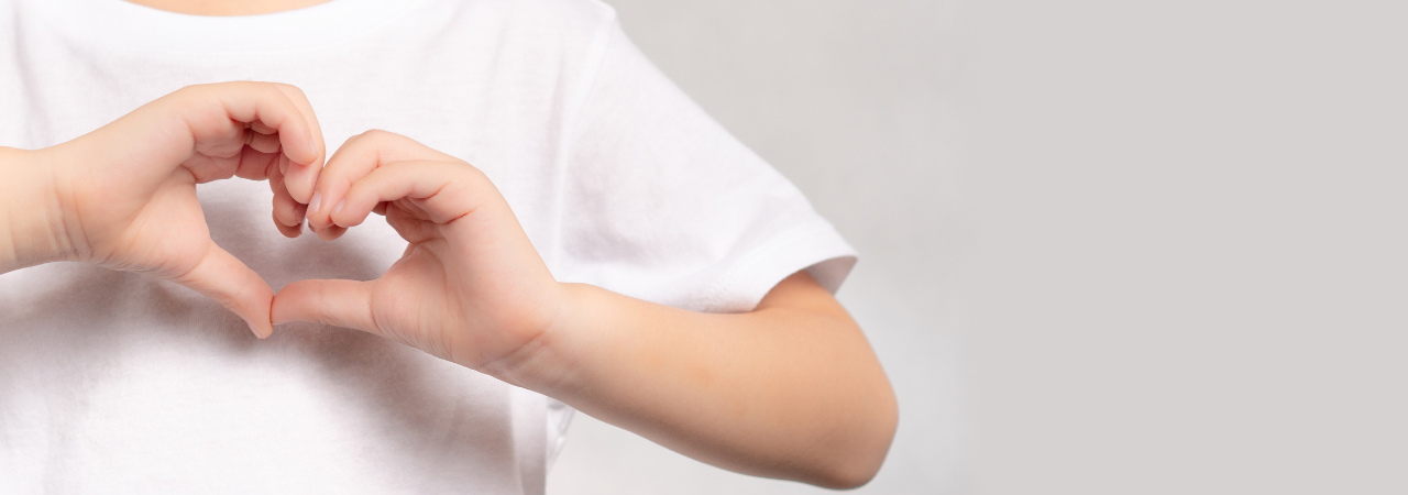 kid creating a heart with his hands