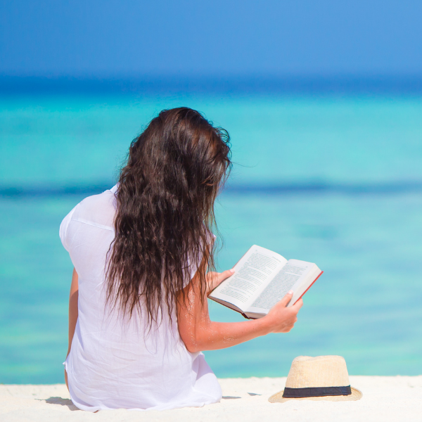 woman reading a book on the beach