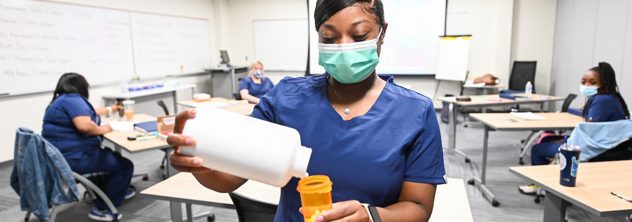 pharmacy tech filling pill bottle
