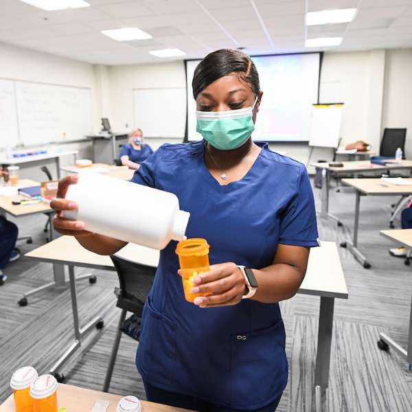 pharmacy tech filling pill bottle