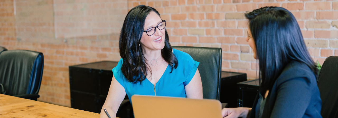 Two female legal assistants talking 