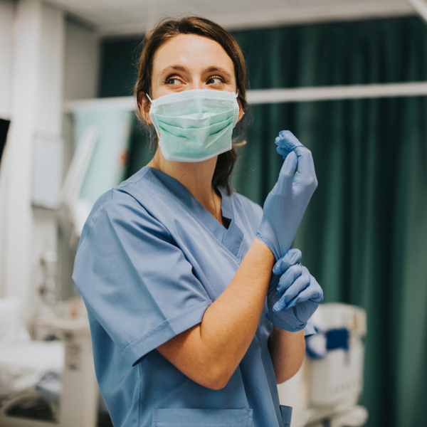 nurse wearing mask and putting on gloves