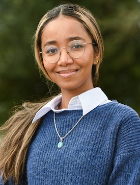 Thowaiba headshot in front of greenery