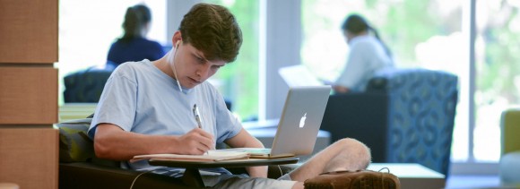 Student sitting down and studying in library