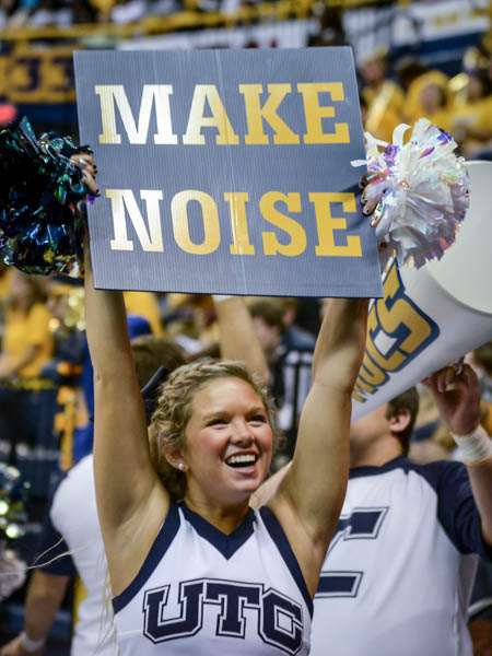 Cheerleader holding sign that says Make Noise