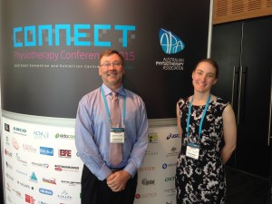 Dr. David Levine standing in front of a sign at the 2015 Australian Physiotherapy conference