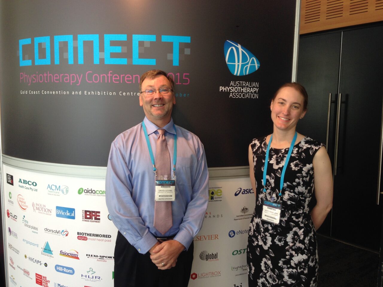 Dr. David Levine standing in front of a sign at the 2015 Australian Physiotherapy conference