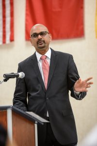 Davan Maharaj speaking behind a podium