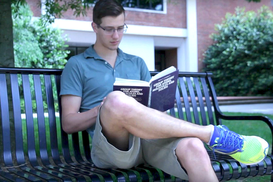 Student Patrick O'Brien reading on campus.