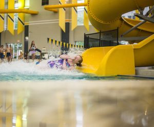 Girl splashes down at end of water slide.