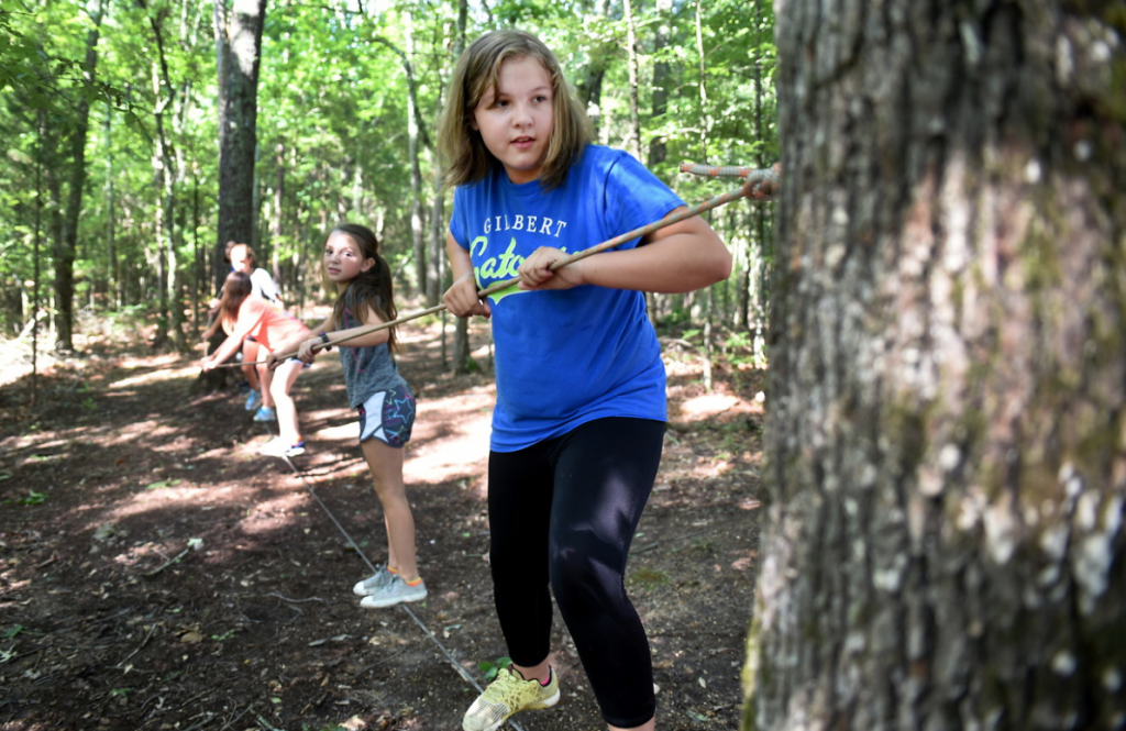 Elementary school student playing on ropes course