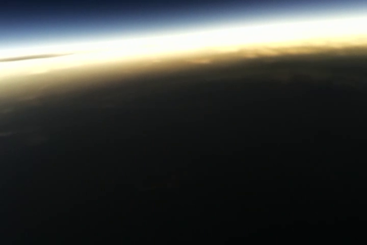 The Earth in the shadow of the Moon during eclipse totality. Sunlight can be seen reflecting off of the clouds at the edge of the shadow. The approximate altitude is 34,000 ft.