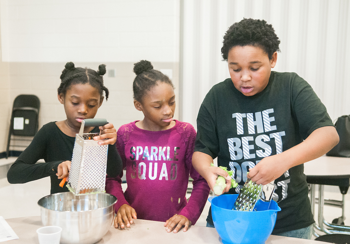William Greer shows his classmates how to grate vegetables