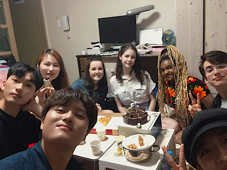 Hannah, in the back, leaning forward and wearing a blue shirt, and a host of the friends she made while in Korea.