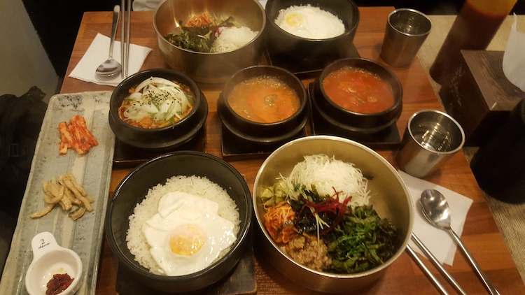 A dinner of Korean food is filled with different dishes.
