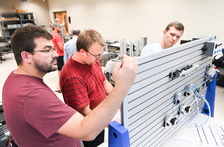 Students, from left, Navar Pickard, Austin Pemberton and Kaleb Thompson examine computer components.
