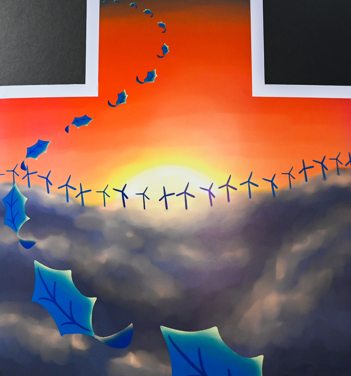 An illustration of blue leaves float in a continuous line getting progressively smaller. In the background there is a bright red sky and a golden sun setting into dark grey clouds. Where the clouds and the sun meet there are small windmills horizontally placed, occupying the width of the artwork.