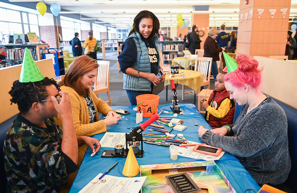 A group of students works on crafts in the library.