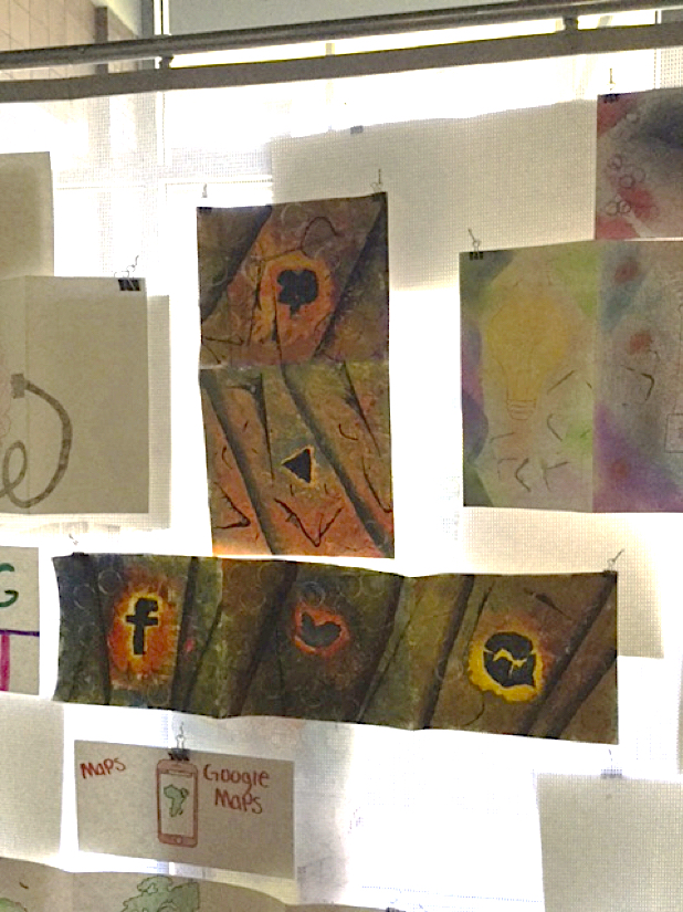 A group of colorful papers are posted up on a board. The art on the small papers resembles popular social media logos on colorful backgrounds.