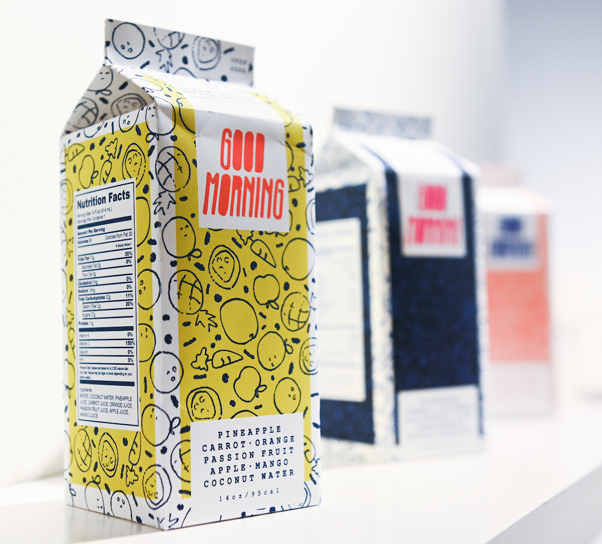 A colorful milk carton covered in shapes and patterns. The carton is titled, "Good Morning" and has an ingredient list of fruits.