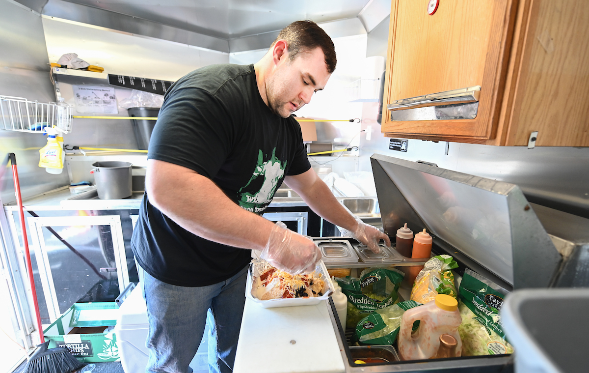Wes Palmer prepares food in his food truck, Amaizeing Eats, Tuesday, Feb. 25, 2020 at Kenco.