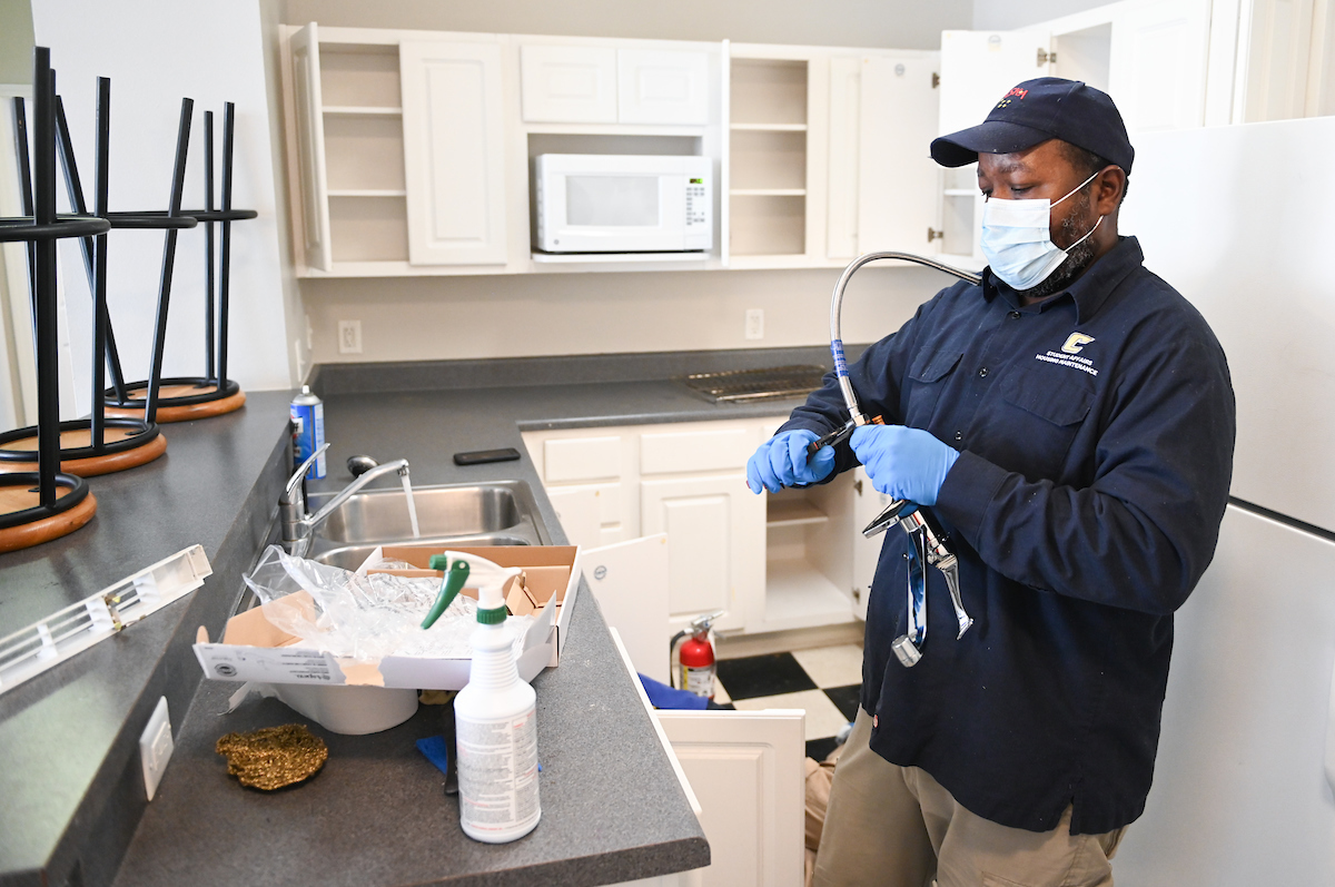 Maintenance man David Lee works on a faucet on April 2, 2020.